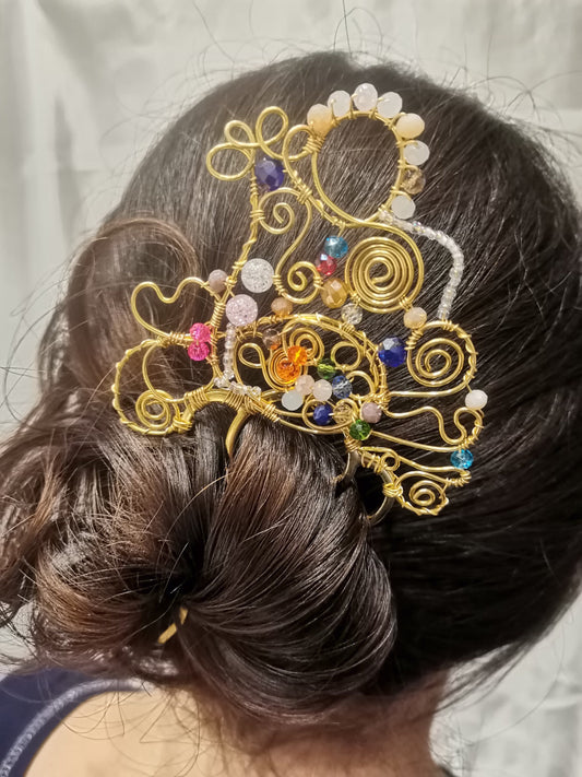 Peina dorada de fantasía con cristales de varios tamaños y colores.