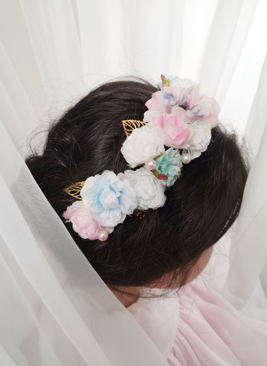 Diadema de comunión con flores de tela de varios colores.