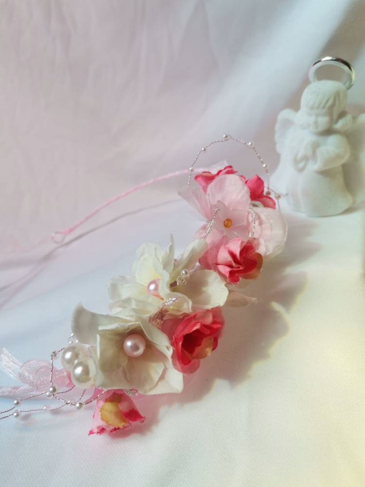 Diadema con flores de tela en tonos rosas, cristal y perlas de imitación.