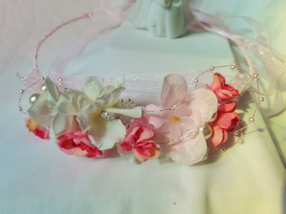 Diadema con flores de tela en tonos rosas, cristal y perlas de imitación.