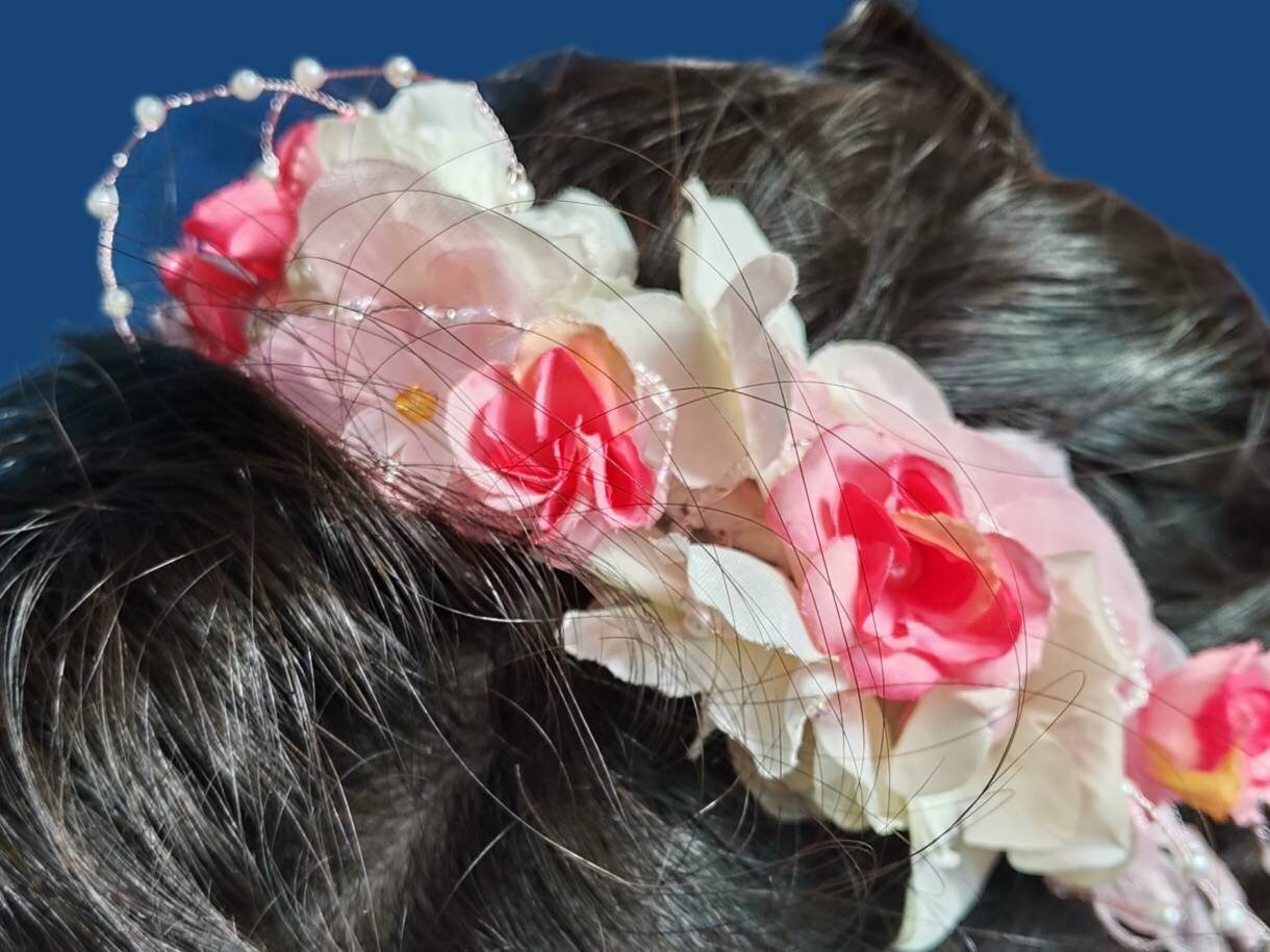 Diadema con flores de tela en tonos rosas, cristal y perlas de imitación.