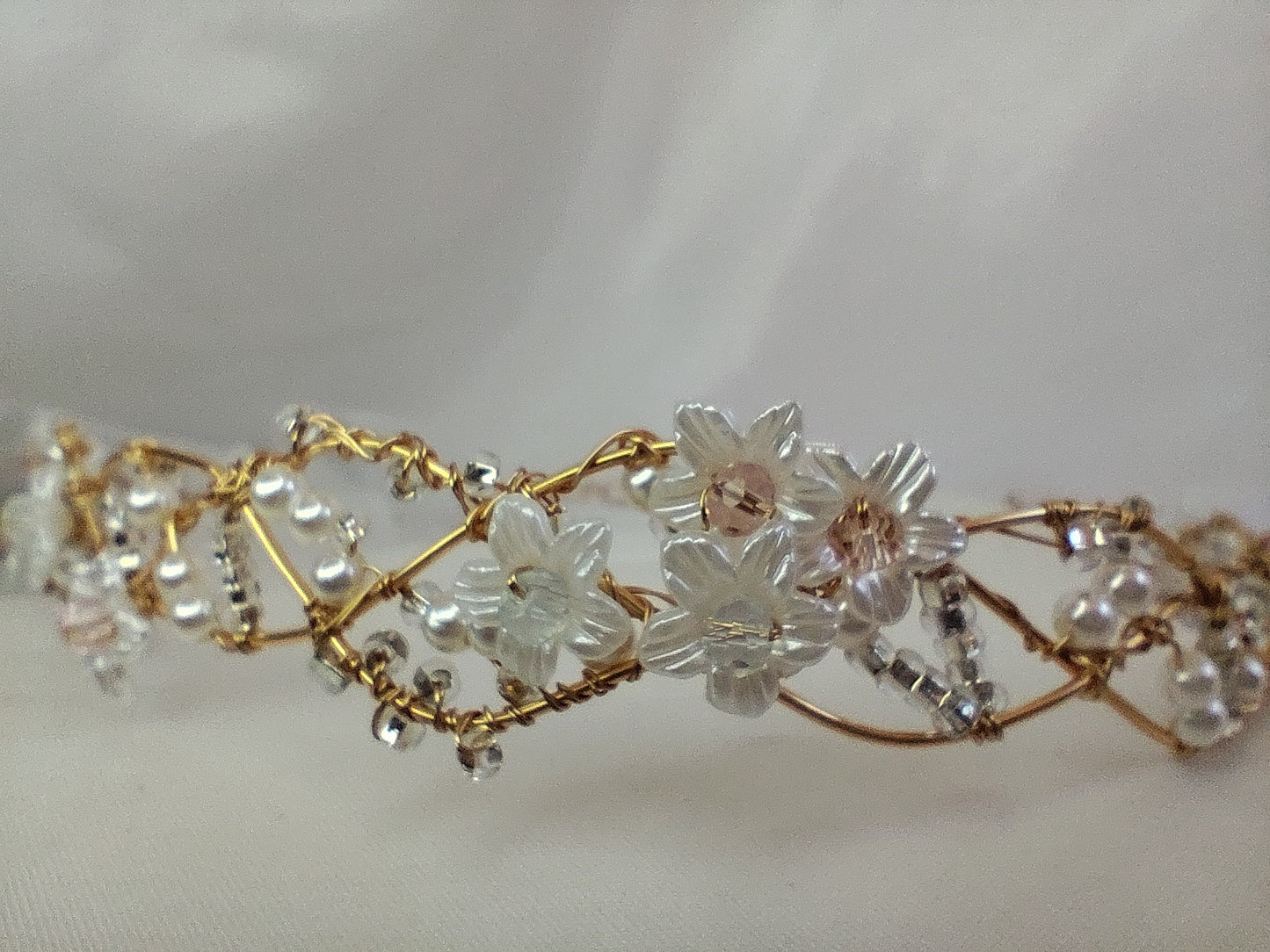 Tiara trenzada de alambre y cristal, con flores.