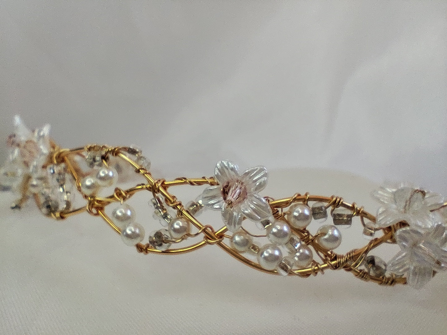 Tiara trenzada de alambre y cristal, con flores.